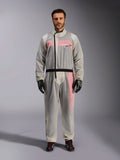 Alpinestars Kart Rain Suit, Clear, transparent waterproof oversuit worn by a model, featuring a black asymmetric zipper and chest logo, red and white racing suit visible underneath, paired with black and neon green gloves and black racing boots.