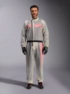Alpinestars Kart Rain Suit, Clear, transparent waterproof oversuit worn by a model, featuring a black asymmetric zipper and chest logo, red and white racing suit visible underneath, paired with black and neon green gloves and black racing boots.