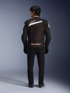 Alpinestars T-GP Plus R V4 Jacket, Black and White sport textile motorcycle jacket, rear view featuring white Alpinestars logo and 'RACING AHEAD' branding, worn with black trousers and boots, streamlined design for performance riding.