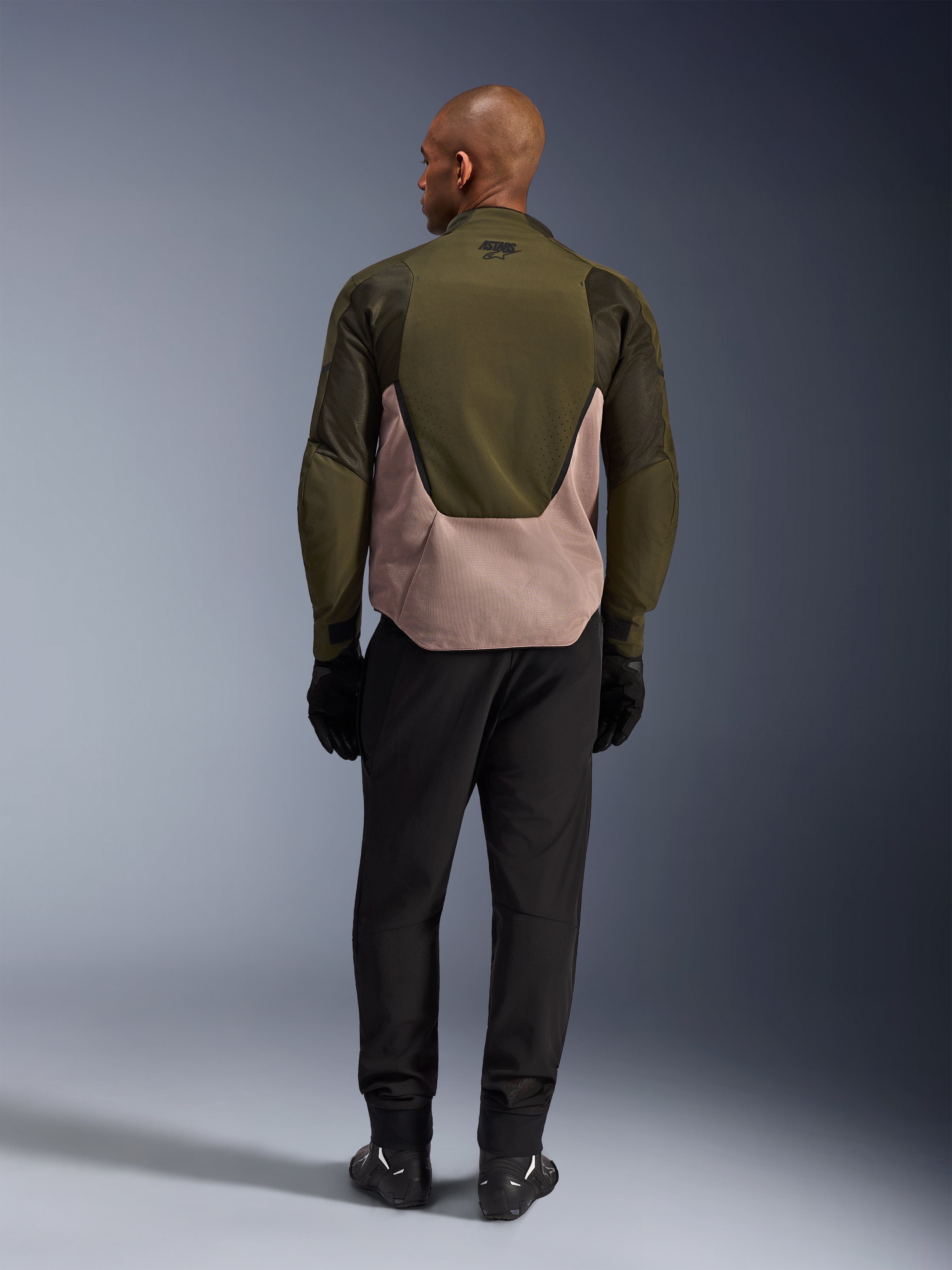 Alpinestars Aeroshell Airflow Jacket in Forest Sand, rear view on rider featuring breathable mesh and laser perforations.