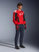 Alpinestars T-GP Air Jacket, Sport Motorcycle Jacket, Bright Red and Black with white accents, worn by a model with dark blue jeans and red racing gloves, featuring high-flow mesh panels and white shoulder sliders, aerodynamic sport fit for warm weather riding.
