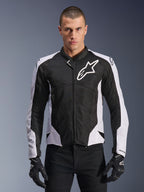 Alpinestars Viper Air V4 Jacket, Motorcycle Racing Jacket, Black and White, worn by rider, tech mesh and textile construction with white shoulder panels, prominent star logo on chest, sport performance design, paired with black riding gloves