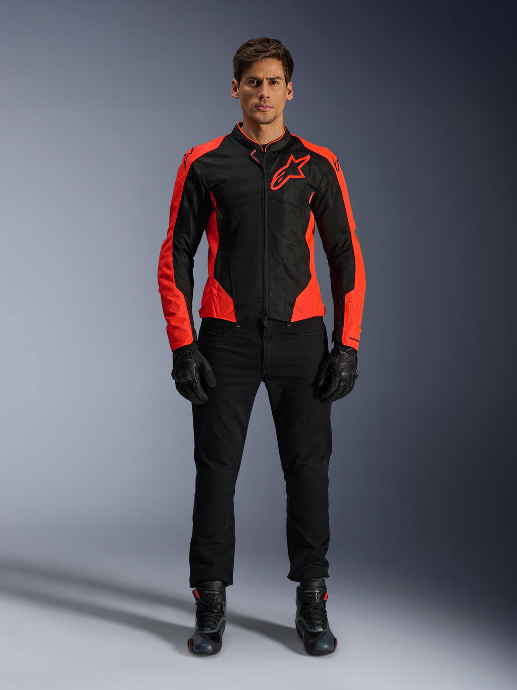 Male model wearing the Alpinestars Viper Air V4 Jacket in Red Fluo and Black, paired with black riding pants, gloves, and boots, featuring breathable mesh panels for ventilation and a bold star logo on the chest, sporty motorcycle road apparel