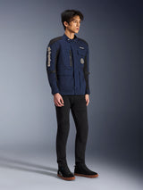 Alpinestars Dice Jacket, Dark Blue and Black, modern field-style motorcycle jacket worn by a model with black pants and black high-top sneakers, featuring multiple utility pockets, vertical Alpinestars branding on the sleeve, and woven patches, urban contemporary riding gear