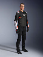 Alpinestars T-Sps Air V2 Jacket, Black White Red Fluo, worn by a male model with black riding pants and gloves, textile motorcycle jacket featuring large mesh panels, white shoulder and forearm sections, and bold Alpinestars logo on the chest.