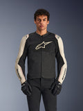 Alpinestars T-SPS Air V2 Jacket, Motorcycle Riding Jacket, Black and Mastic Aluminum, male model wearing jacket with black pants and gloves, featuring mesh panels for ventilation, large Alpinestars logo on the chest, and sporty fitted design