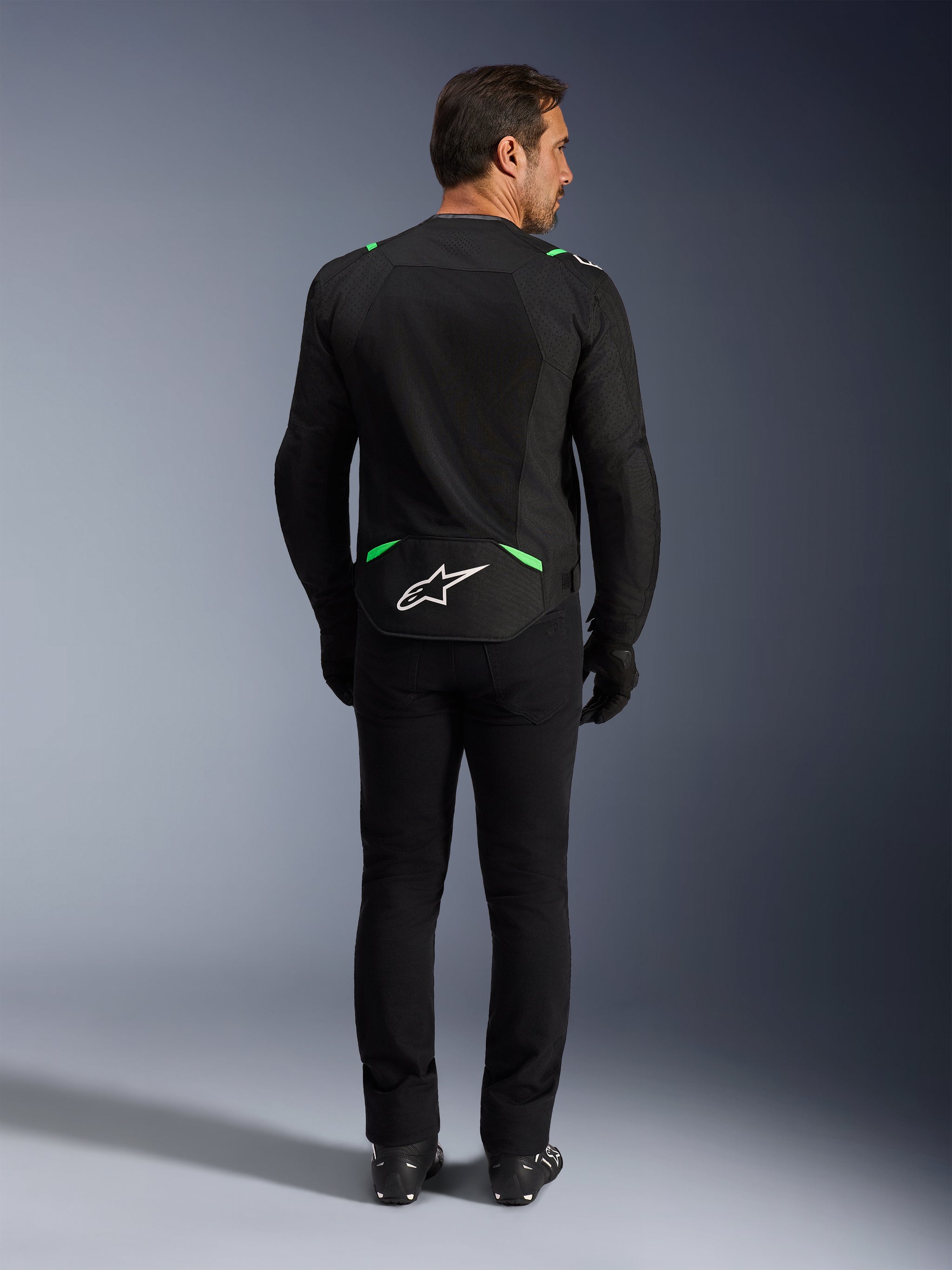 Alpinestars T-SPS Air V2 Jacket, Motorcycle Jacket, Black and Fluo Green, rear view featuring white logo on lower back, worn with matching black pants and boots, ventilated mesh design for sport riding