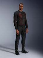 Alpinestars Troop-Air Pro Jacket in Black Red Fluo, technical armored mesh motorcycle jacket worn by a male model with matching black armored pants and high-top boots, full-length studio portrait.
