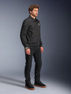 Alpinestars Ignite Air Jacket, Urban Motorcycle Jacket, Black, worn by a model with black pants and black sneakers, featuring a traditional shirt collar, club-inspired graphics on the chest and cuffs, sleek contemporary design with mesh and satin finish