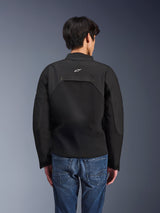Alpinestars Provoke Jacket, Urban Motorcycle Jacket, Black, rear view showing white Astars logo and technical ripstop panels, worn with blue denim jeans, contemporary design for city commuting