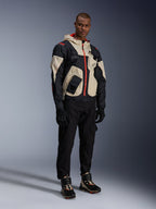 Alpinestars Acteon Pants, Black motorcycle pants, worn with a black, beige, and red Mogress Air Jacket, black riding gloves, and matching high-top riding sneakers, contemporary urban motorcycle gear for men