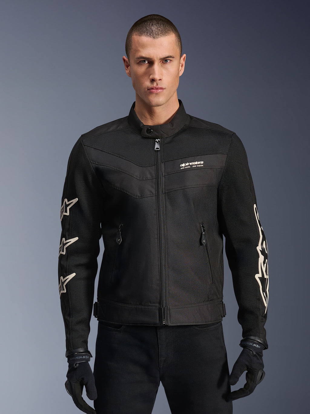 Alpinestars T-Dyno Air Jacket, Black textile motorcycle jacket, featuring white star graphics on sleeves and logo on chest, mesh panels for ventilation, vintage-inspired biker fit, worn with black gloves and pants