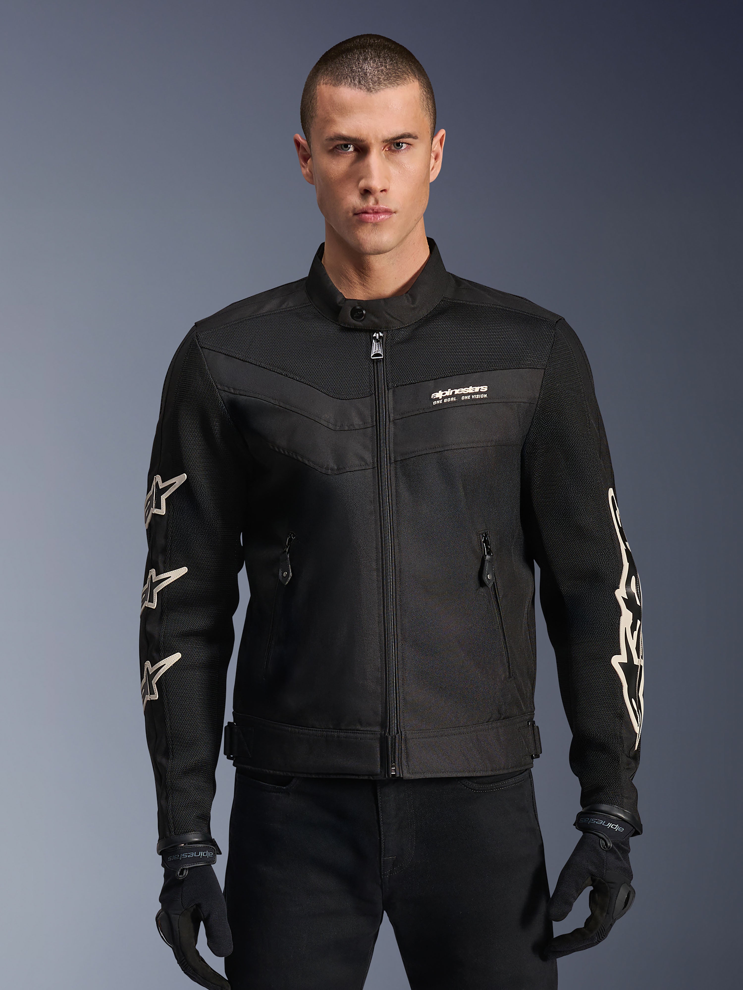 Alpinestars T-Dyno Air Jacket, Black textile motorcycle jacket, featuring white star graphics on sleeves and logo on chest, mesh panels for ventilation, vintage-inspired biker fit, worn with black gloves and pants