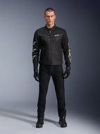 Male model wearing Alpinestars T-Dyno Air Jacket, Black, lightweight textile motorcycle jacket with breathable 3D mesh, white star logos on sleeves, paired with black pants, gloves, and boots, front view standing