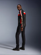 A man wearing the Alpinestars T-Dyno Air Jacket in Black, Bright Red, and Ecru, vintage-inspired textile motorcycle jacket with mesh panels, bold branding on the sleeve, paired with black pants and boots for a modern biker look