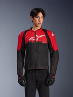 Alpinestars SMX Air Jacket, Motorcycle Mesh Jacket, Bright Red and Black, worn by a model with black riding gloves, featuring a large white logo on the chest, ventilated textile construction with red shoulder panels and black sleeves, sporty performance gear for warm-weather riding