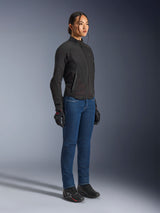 Female rider wearing the Alpinestars Stella Aeroshell Airflow Jacket in Black Anthracite, slim-fit softshell motorcycle jacket, paired with blue riding jeans and black gloves, full-body studio view