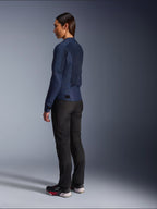 Woman wearing Alpinestars Stella C-1 Air Jacket in Blue, rear three-quarter view, showcasing mesh back panels and adjustable waist tabs, paired with black riding pants and black sneakers, urban motorcycle apparel