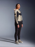 Alpinestars Molly Air Jacket in Black Almond, worn by a female rider with black pants and cream high-top sneakers, featuring a two-tone design with black and beige panels, integrated hood, and contemporary urban style.