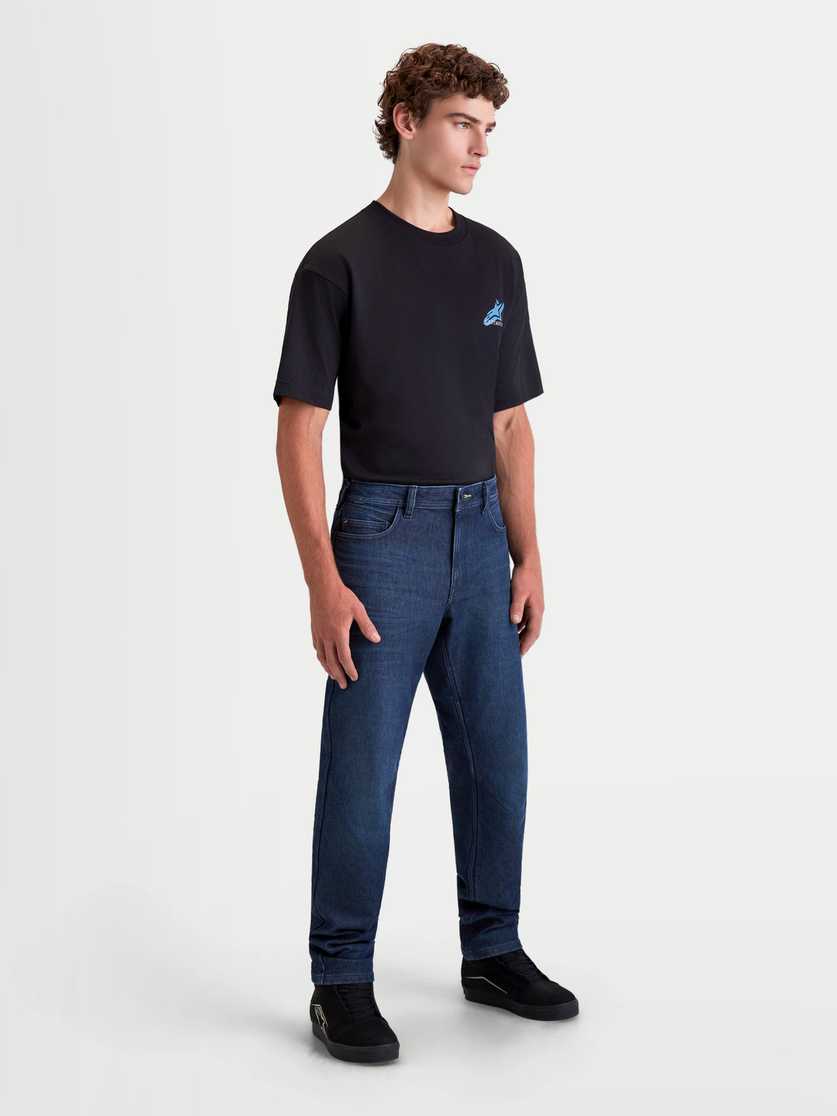 Alpinestars Flex-AST 10 Tough Max Denim Pants, men's motorcycle denim pants in dark blue, three-quarter view on a model wearing an urban riding outfit, AAA certified technical denim with single-layer construction