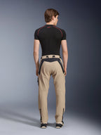 Alpinestars Acteon Pants in Sand, modern urban motorcycle pants viewed from the back, featuring black panels with white Alpinestars branding, tapered fit with zippers at the hem, worn with a black short-sleeved base layer and sneakers.