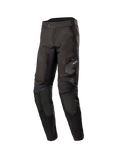 Alpinestars Venture XT In Boot Pants, Men's Adventure Touring Motorcycle Pants, Black, front three-quarter view featuring water-resistant textile construction, zippered thigh pocket with Astars logo, and reinforced knee panels.