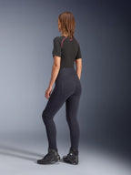 Alpinestars Woman Stella Flex-Ast Leggings, Black, rear view showing high-waisted fit and back pockets, worn with a black short-sleeve base layer with red accents and black motorcycle shoes, urban contemporary motorcycle gear
