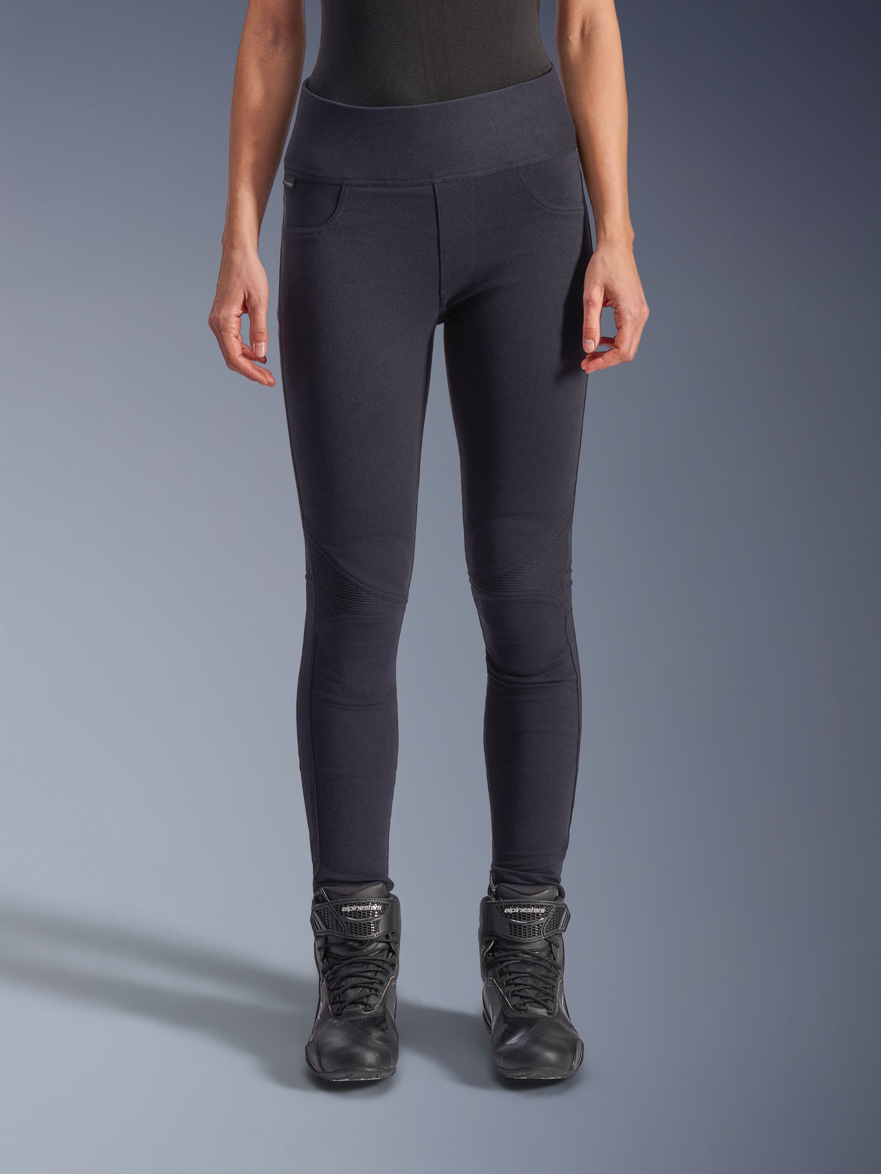 Alpinestars Woman Stella Flex-AST Leggings - Short, Women's Motorcycle Riding Leggings in Black, high-waisted skinny fit with accordion knee panels, worn with black Alpinestars riding boots, urban riding gear