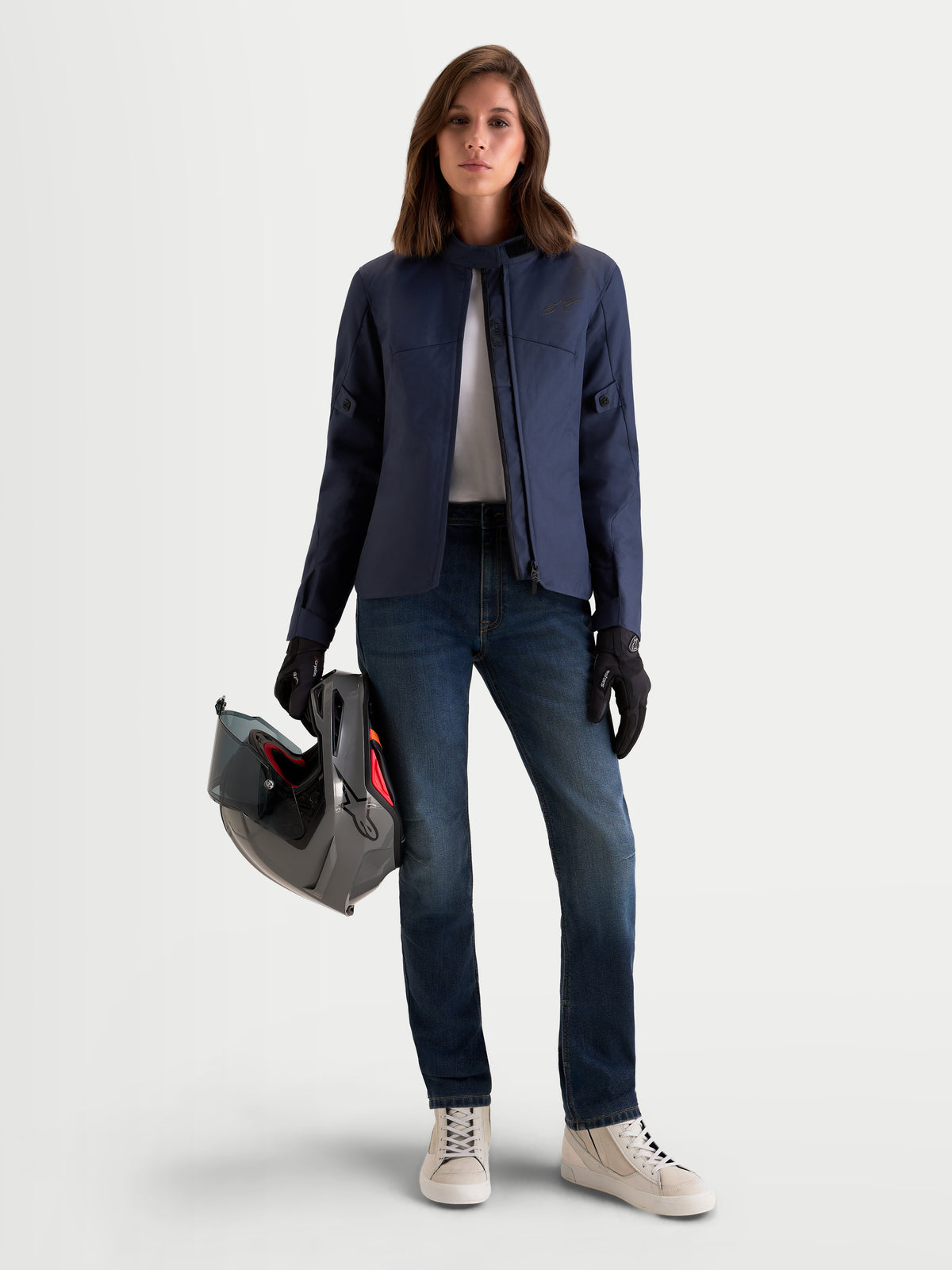 Alpinestars Stella Flex-AST 5 Denim Pants, women's urban motorcycle denim jeans in indigo washed blue, worn by a model holding a motorcycle helmet and matching riding gear, front view