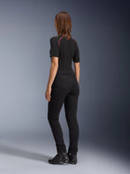 Alpinestars Womens Banshee Leggings, Black, rear view showing figure-hugging anatomical stretch fit and back pockets, worn with a black short-sleeved top and motorcycle boots, sleek urban motorcycle gear for women