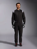 Alpinestars KMX-9 V3 Suit, Black and White Karting Suit, full-length view on a model, featuring white shoulder logos and accents, styled with black and white racing gloves and black shoes with red laces, athletic-regular fit for professional karting gear.