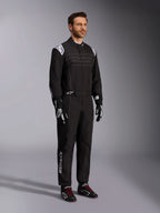 Alpinestars KMX-9 V3 Karting Suit, Black and White, male model wearing full racing suit with white Alpinestars logo on epaulettes, paired with black and white racing gloves and black karting shoes with red laces, studio shot showing the front and side profile