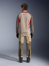 Alpinestars Maxdura Dual Jersey in Aluminum Walnut, back view, tan mesh torso with brown sleeves and red logos, dropped rear hem, paired with adventure riding pants and black boots.