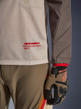 Alpinestars Maxdura Dual Jersey in Aluminum Walnut, detailed view showing the ventilated mesh torso with red branding, abrasion-resistant sleeve with integrated padding, worn with coordinated adventure riding pants and gloves