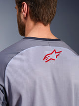 Alpinestars Maxdura Dual Jersey in Mid Gray and Dark Gray, close-up of the upper back and collar, features a small red Alpinestars star logo on breathable light gray mesh fabric with dark gray neck trim, designed for adventure off-road riding