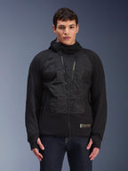 Alpinestars MO.ST.EQ Hybrid Hooded Jacket, Black urban motorcycle jacket, model wearing mid-season padded hoodie with angled front zipper, seamless padded chest panels, thumb loops, and a hood, modern streetwear-inspired riding gear