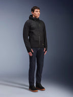 Alpinestars MO.ST.EQ Hybrid Hooded Jacket, black mid-season padded hoodie with an angled front zipper, worn by a male model with dark blue jeans and black sneakers, urban contemporary motorcycle gear.