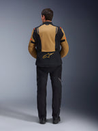 Alpinestars ST-7 2L GORE-TEX Jacket, Adventure Motorcycle Jacket, Gobi Brown and Black, back view showing ergonomic paneling and Alpinestars logo, worn with black riding pants and boots, waterproof touring gear