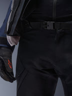 Alpinestars ST-7 2L GORE-TEX Pants, Black, close-up of the waist featuring a magnetic buckle closure and durable technical textile construction, worn with matching adventure touring jacket and black gloves with a red logo.