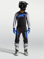 Alpinestars Supertech Hiten AFD Pants, black and blue motocross gear, on-model with matching jersey and white racing boots.