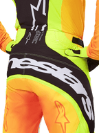 Alpinestars 2025 Techstar Melt Pants, Motocross Pants, Rear view close-up, Neon Yellow and Orange with Black panels, large white Alpinestars branding across the seat, performance off-road riding gear