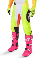 Alpinestars 2025 Techstar Melt Pants, Motocross Pants, Neon Yellow with White and Orange Accents, Black Side Patterns, worn with bright pink motocross boots and neon yellow gloves, featuring perforated ventilation, durable off-road racing gear
