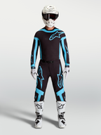 Alpinestars Supertech Vesta Pants, men's motocross racing gear in black and turquoise, featuring lightweight stretch construction on model.