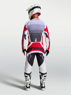 Alpinestars Techstar Maven motocross pants in Fire Red and White, rear view on a rider showing athletic race fit.