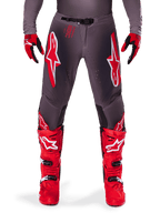 Alpinestars 2025 Supertech Lipan Pants, Motocross Pants, Smoke Bright Red, gray chassis with prominent red and white logos, styled with red racing boots and gloves, featuring perforated ventilation, high-performance off-road gear