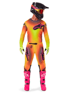 Motocross rider wearing the Alpinestars 2025 Supertech Lipan gear, featuring a vibrant Yellow and Pink gradient design, matching long-sleeved jersey, bright pink boots, lime green gloves, and a black helmet with orange goggles.