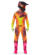 Motocross rider wearing the Alpinestars 2025 Supertech Lipan gear, featuring a vibrant Yellow and Pink gradient design, matching long-sleeved jersey, bright pink boots, lime green gloves, and a black helmet with orange goggles.