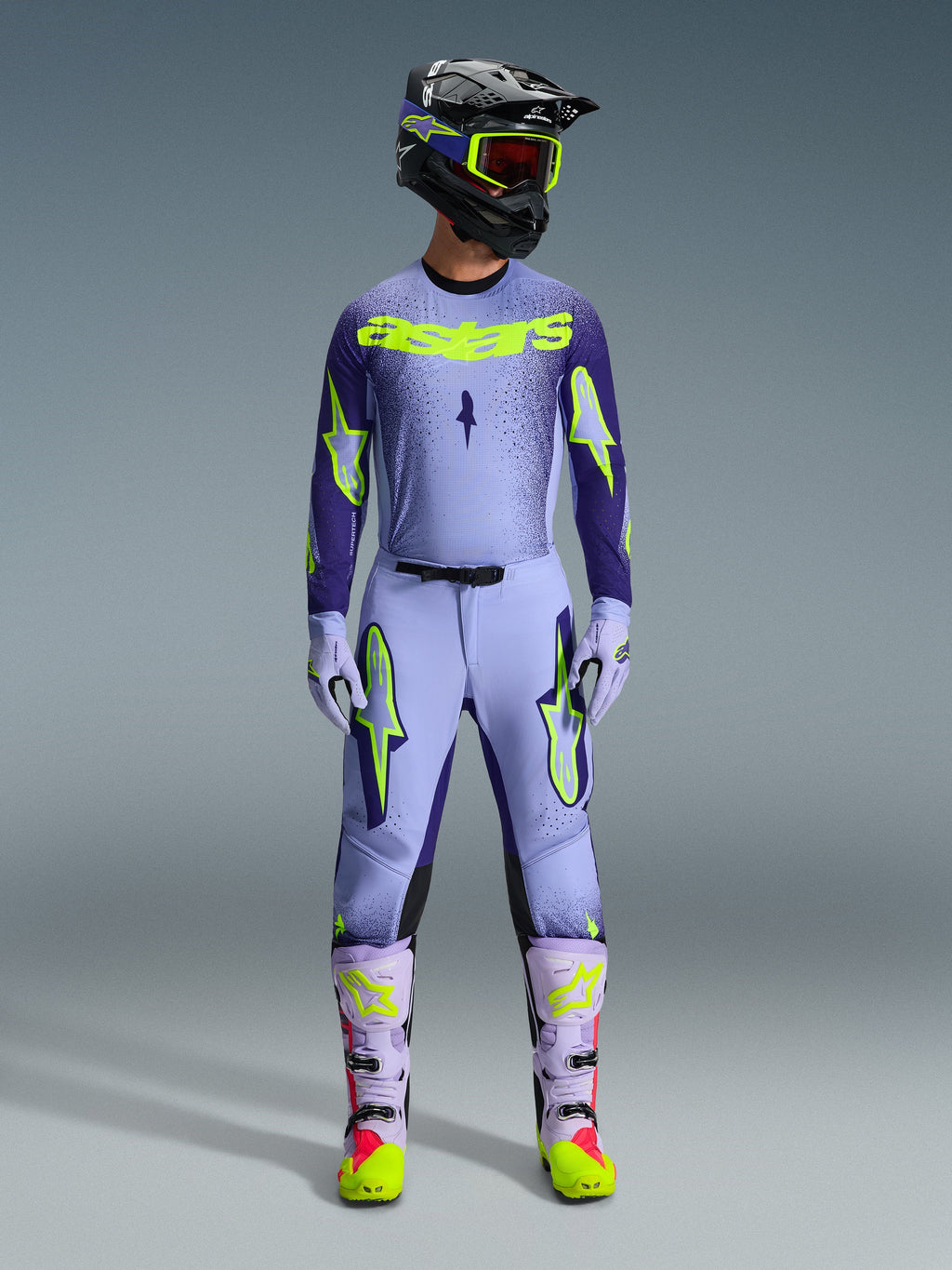 Alpinestars 2026 Supertech Scenz Pants, Motocross Pants, Purple Yellow Fluo, worn as a complete racing gear set with matching lavender jersey, gloves, and boots, featuring bold yellow fluo logos, athletic fit design for professional off-road racing.