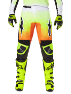Alpinestars 2025 Fluid Wurx Pants, Motocross Pants, Neon Yellow and Orange, Black and White Star Logos, Sleek Racing Design with Black Knee Sections, coordinated with matching neon yellow boots and gloves
