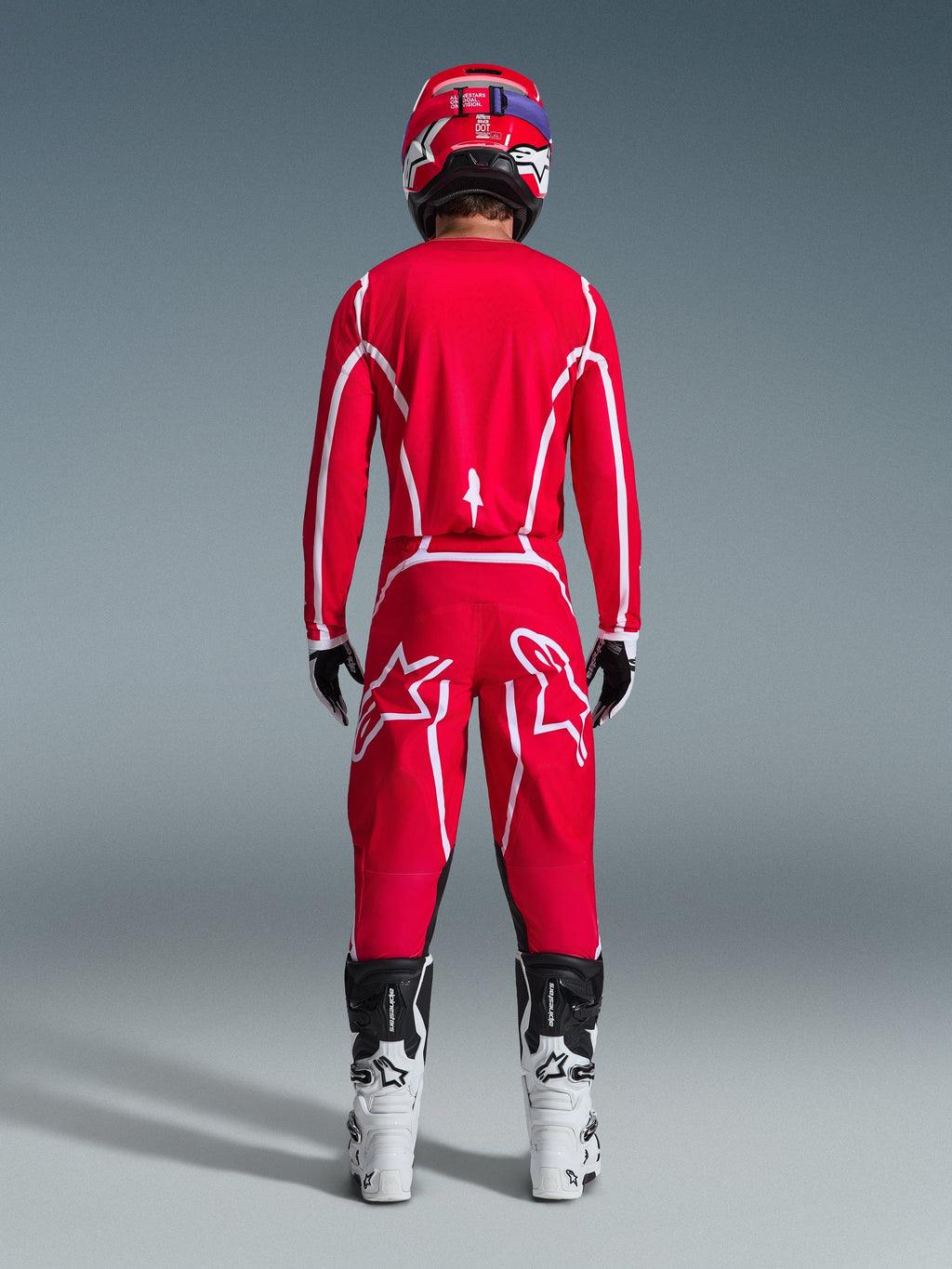 Alpinestars 2026 Fluid Apex Pants, Motocross Pants, Red and White, rear view worn with matching jersey, red helmet, and white and black boots, featuring large white Astar logos on the legs, coordinated outfit for off-road racing